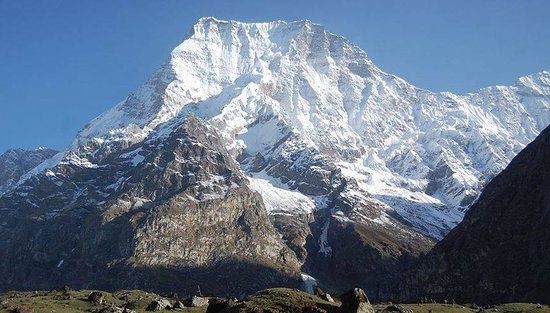 Snow peaks of the far western Nepal Himalaya rising above forested ridges